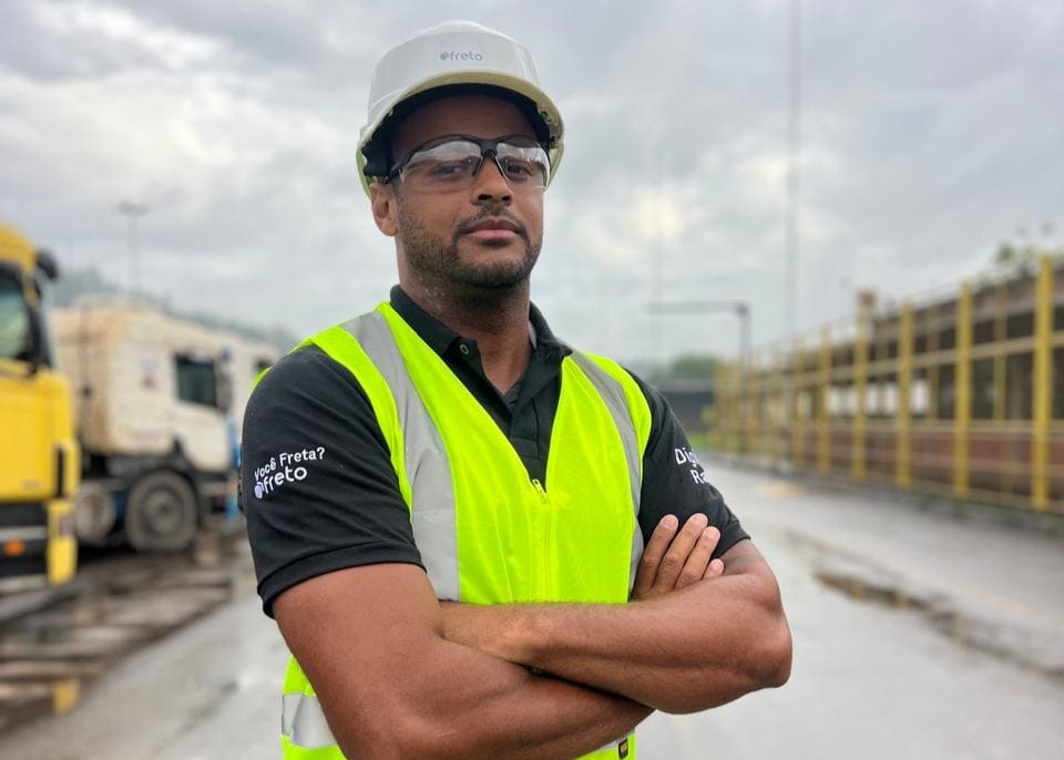 Funcionário de uma transportadora, utilizando uniforme e equipamentos de segurança.