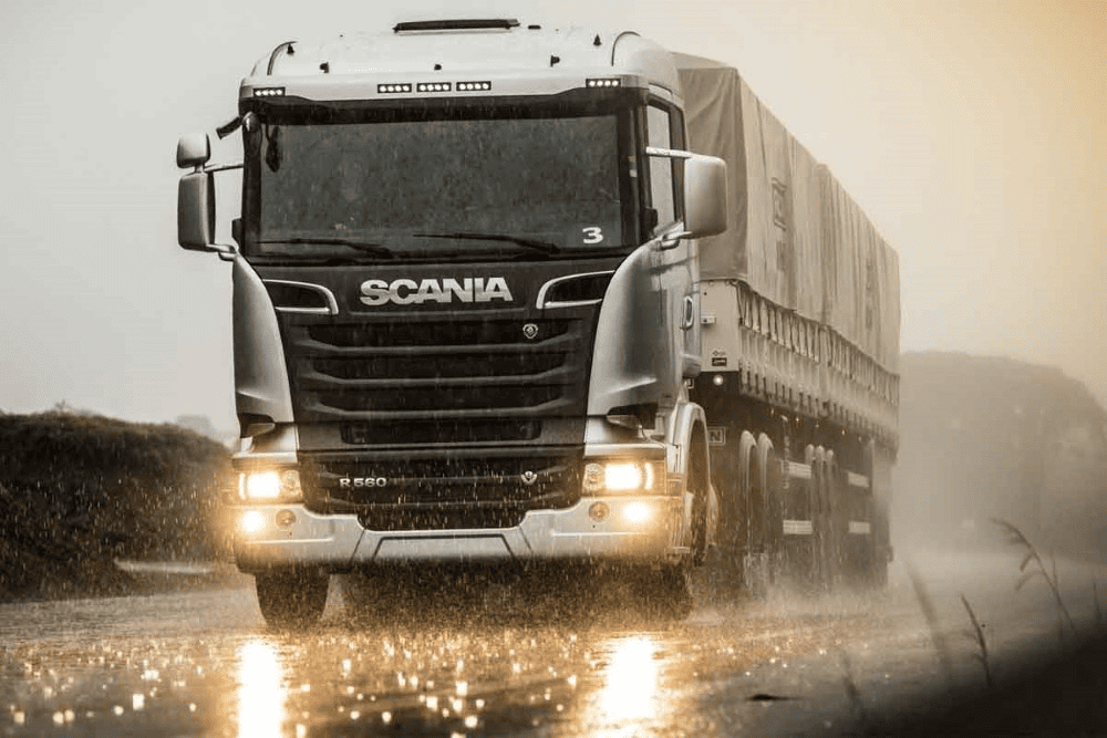 Caminhão na estrada realizando transporte de cargas, na chuva